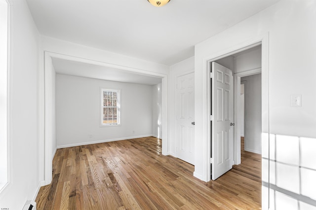 spare room with a baseboard radiator and light wood-type flooring