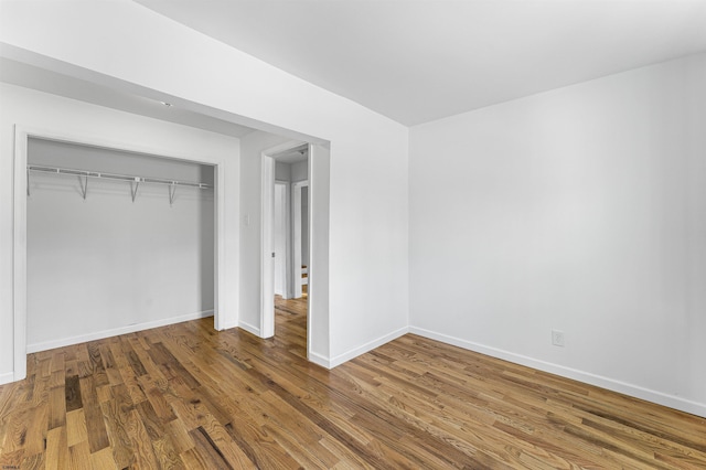 unfurnished bedroom featuring a closet and wood-type flooring