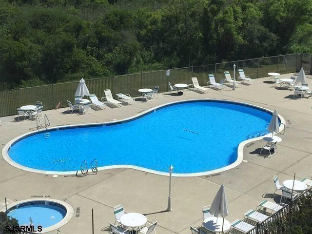 community pool featuring fence and a patio