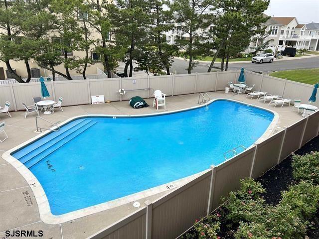 community pool featuring fence and a patio