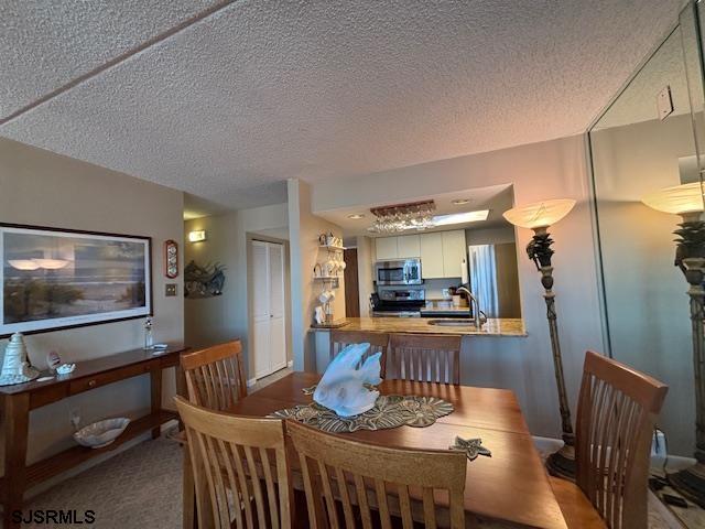 carpeted dining room with a textured ceiling and a sink