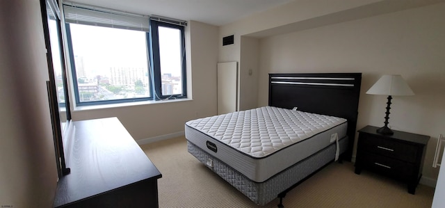 bedroom featuring light carpet and multiple windows