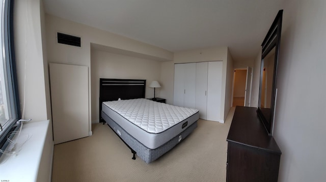 bedroom featuring light colored carpet and a closet