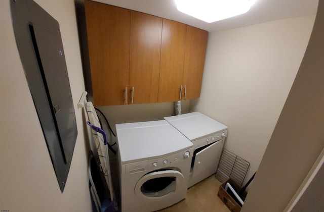 laundry room featuring washer and dryer and cabinets