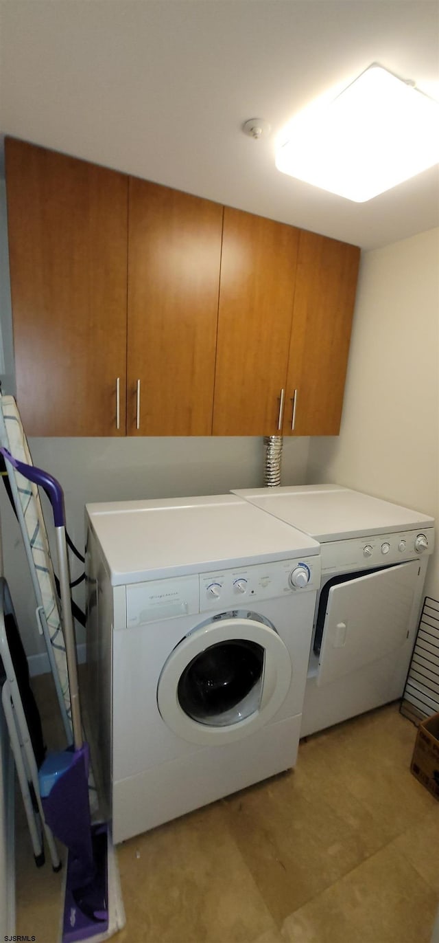 washroom with washer and clothes dryer and cabinets