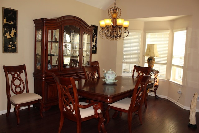 dining space with dark hardwood / wood-style floors and a chandelier