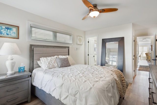 bedroom featuring ceiling fan, light wood-type flooring, and multiple windows