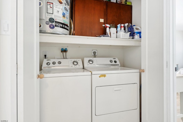 clothes washing area with washer and dryer and water heater