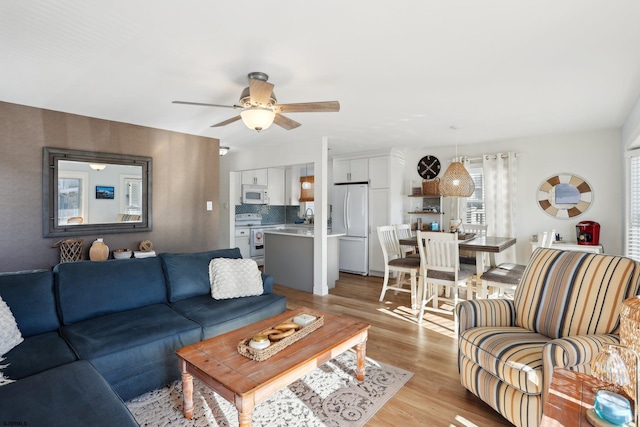 living room featuring ceiling fan, light hardwood / wood-style floors, and sink