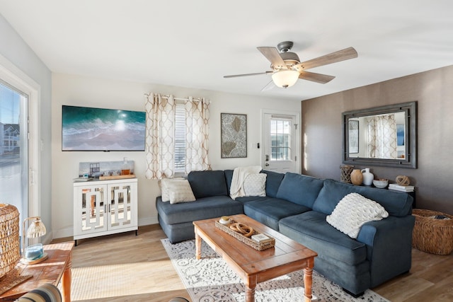 living room with light wood-type flooring, a wealth of natural light, and ceiling fan