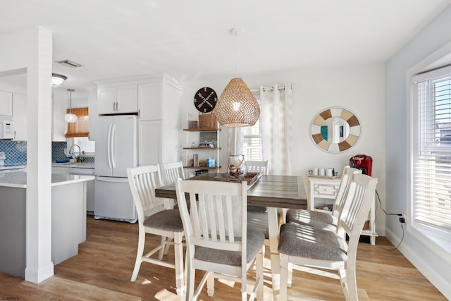 dining room featuring sink and light hardwood / wood-style flooring