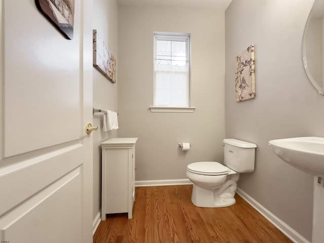 bathroom featuring wood-type flooring and toilet