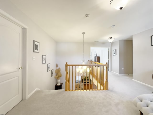 hallway with carpet floors and a chandelier