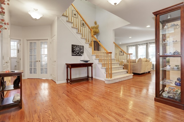 foyer with french doors and light hardwood / wood-style flooring