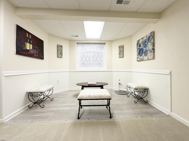 unfurnished room featuring wood-type flooring and a drop ceiling