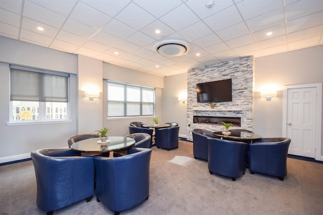 dining space featuring a stone fireplace and carpet floors