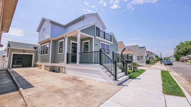 view of front of property featuring covered porch, an outdoor structure, and a garage