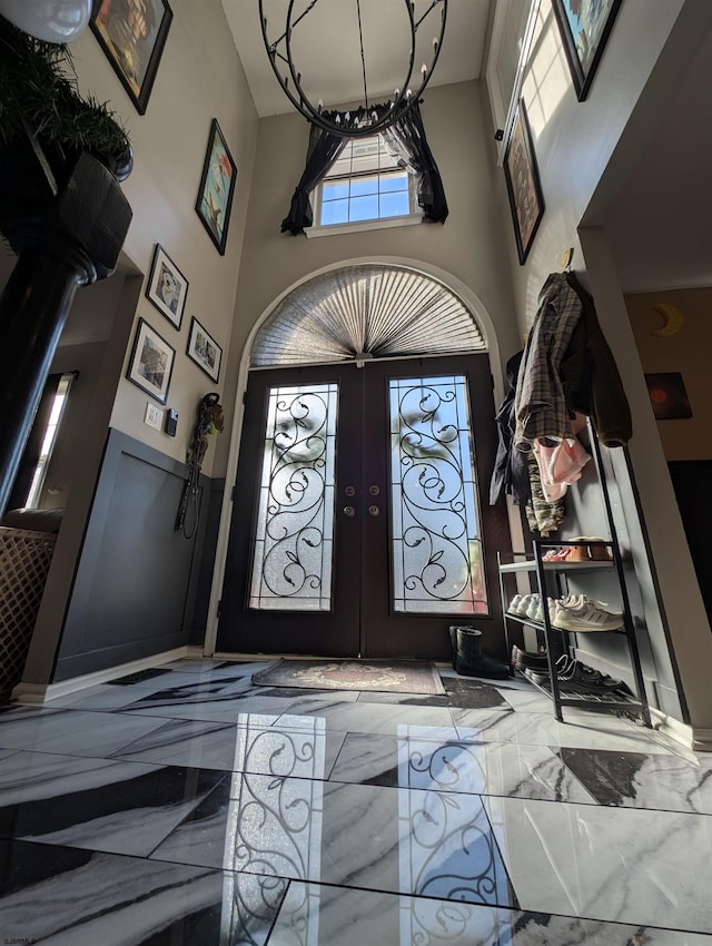 foyer with french doors and a towering ceiling