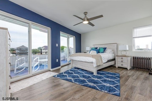 bedroom featuring hardwood / wood-style floors, ceiling fan, radiator heating unit, and access to outside