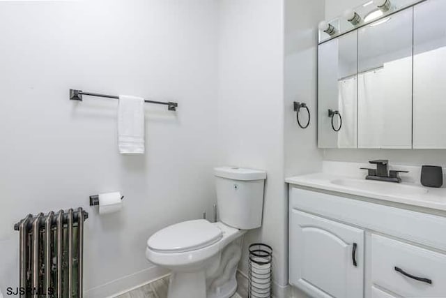 bathroom featuring radiator heating unit, vanity, and toilet