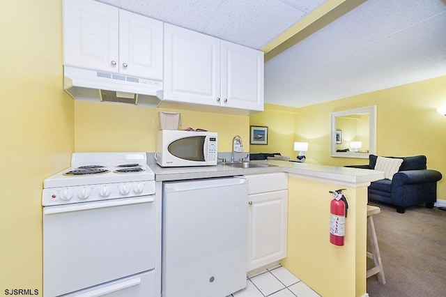 kitchen featuring white appliances, white cabinets, sink, light tile patterned floors, and kitchen peninsula