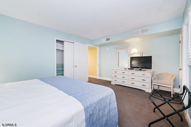 carpeted bedroom with a closet and a textured ceiling