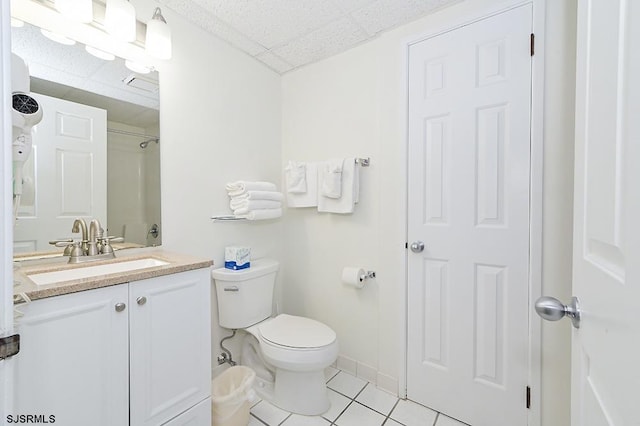 bathroom featuring tile patterned flooring, vanity, a paneled ceiling, and toilet