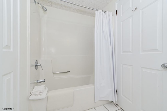 bathroom featuring shower / bath combo with shower curtain, tile patterned flooring, and a textured ceiling