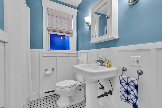 bathroom featuring tile patterned floors, a baseboard heating unit, and toilet