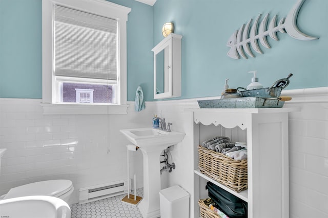 bathroom featuring tile patterned flooring, a baseboard radiator, toilet, and tile walls