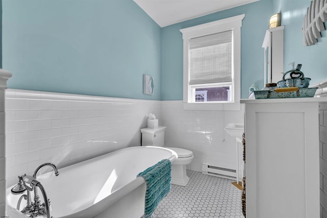 bathroom with tile patterned flooring, toilet, tile walls, a tub to relax in, and a baseboard radiator