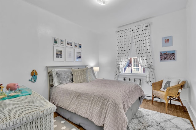 bedroom featuring wood-type flooring and baseboard heating