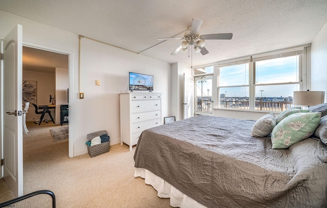 bedroom featuring ceiling fan, a textured ceiling, and light carpet