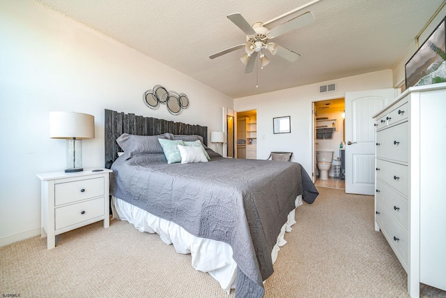 carpeted bedroom with ceiling fan, a textured ceiling, and connected bathroom