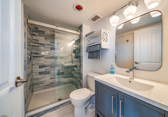 bathroom featuring vanity, toilet, and a shower with door