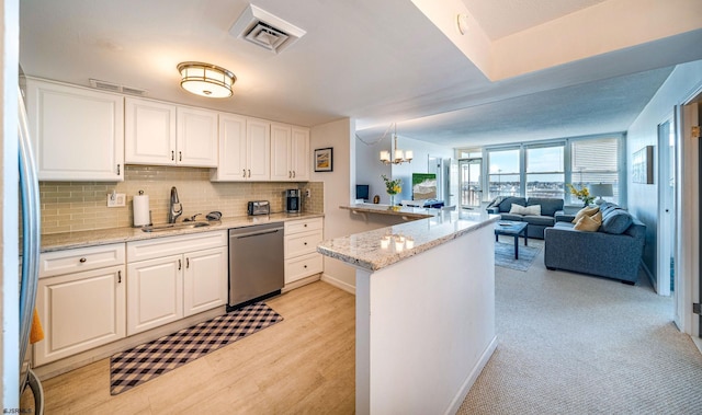 kitchen featuring white cabinets, dishwasher, sink, and decorative light fixtures