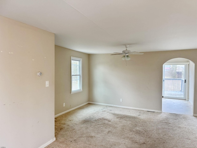 carpeted spare room with ceiling fan and a healthy amount of sunlight