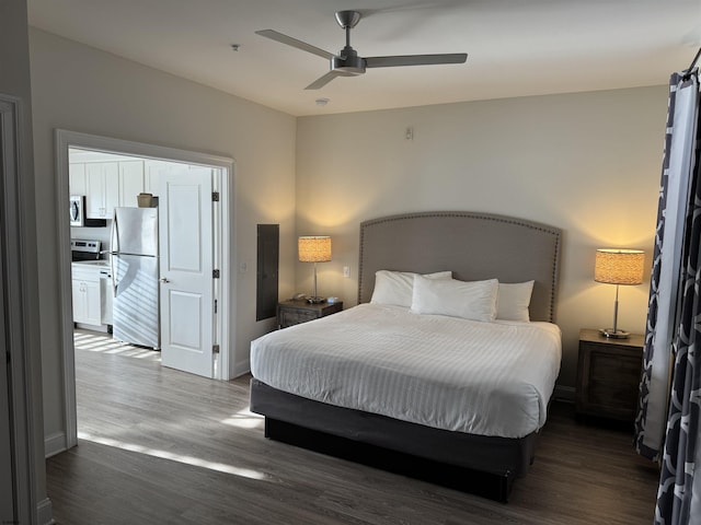 bedroom with dark hardwood / wood-style flooring, stainless steel refrigerator, and ceiling fan