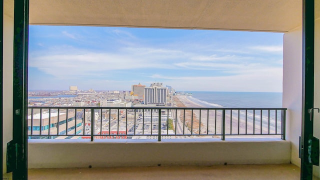 balcony with a water view and a view of the beach