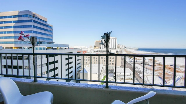 balcony featuring a water view and a beach view