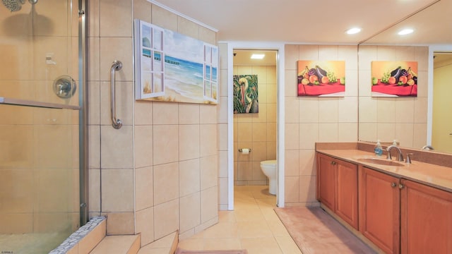 bathroom with an enclosed shower, vanity, tile walls, tile patterned flooring, and toilet