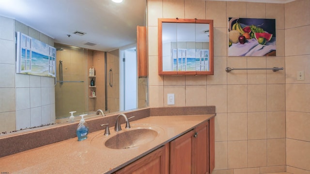 bathroom featuring vanity and tile walls