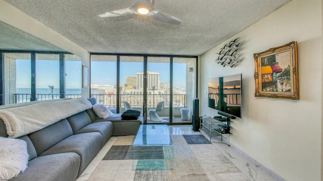 living room with floor to ceiling windows, ceiling fan, and a textured ceiling