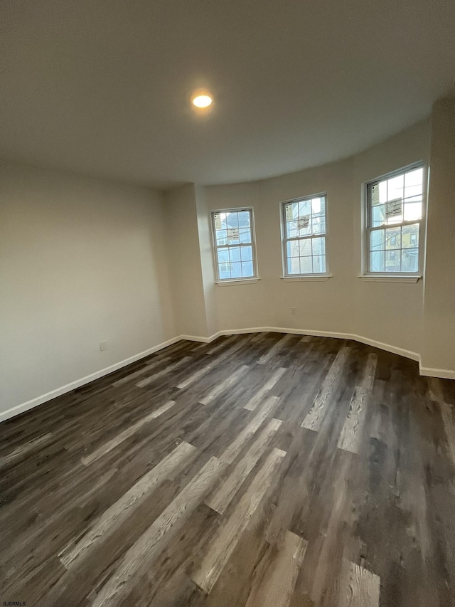 unfurnished room with dark hardwood / wood-style flooring