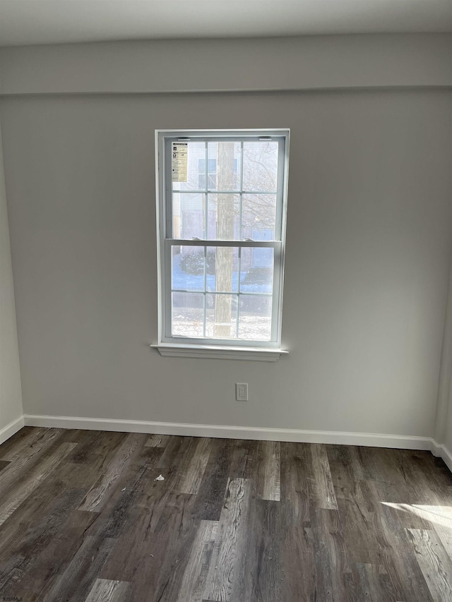 unfurnished room with a wealth of natural light and dark wood-type flooring