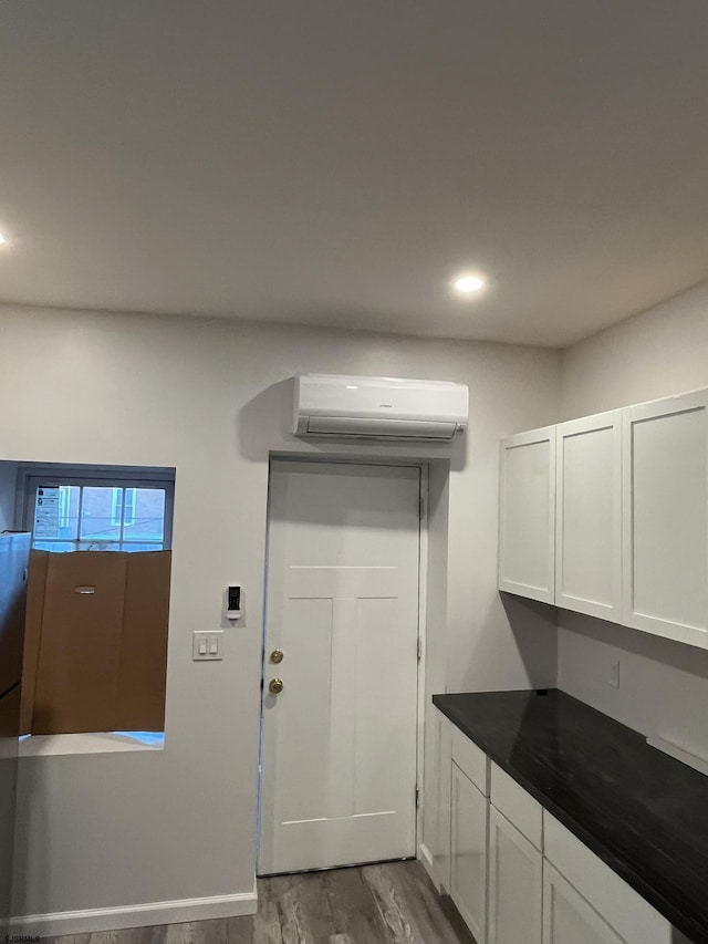 interior space with wood-type flooring and a wall mounted AC