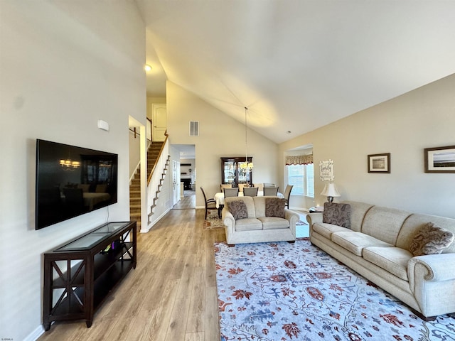 living room featuring light hardwood / wood-style floors and high vaulted ceiling