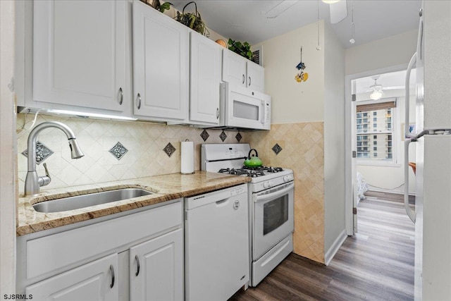 kitchen featuring white cabinetry, sink, light stone countertops, and white appliances