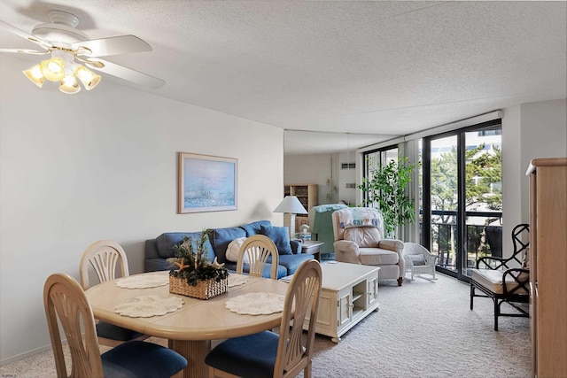 dining space featuring a textured ceiling, ceiling fan, floor to ceiling windows, and light carpet