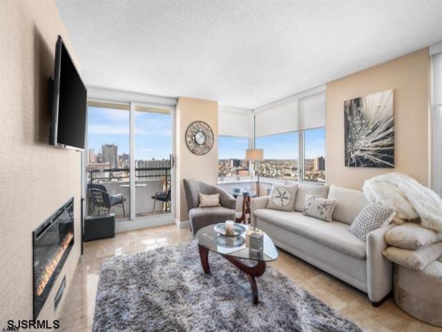 living room with a textured ceiling and a wall of windows